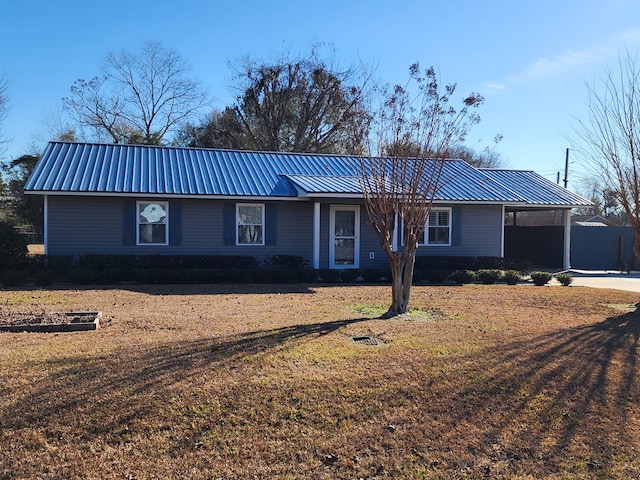 single story home featuring concrete driveway, a carport, a front yard, and metal roof