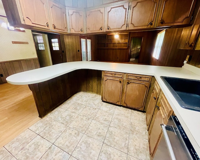 111 Van Deman Ct, Fitzgerald, GA 31750 - kitchen featuring a peninsula, stainless steel dishwasher, light countertops, wooden walls, and a wainscoted wall