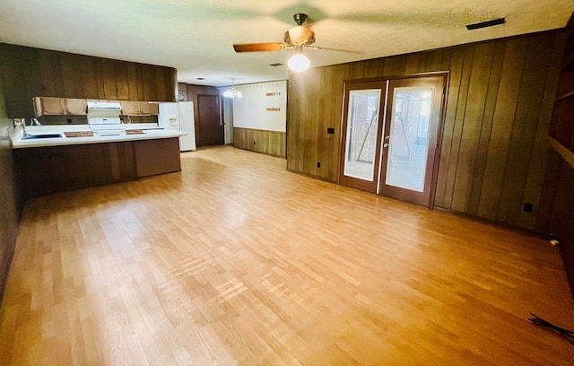 111 Van Deman Ct, Fitzgerald, GA 31750 - kitchen featuring white fridge with ice dispenser, a peninsula, light countertops, wood walls, and light wood-style flooring