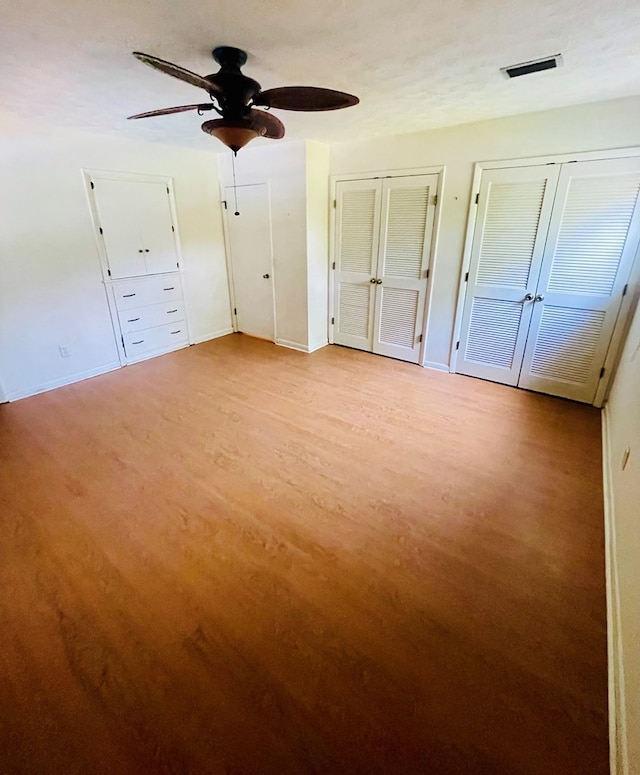 111 Van Deman Ct, Fitzgerald, GA 31750 - unfurnished bedroom featuring multiple closets, baseboards, light wood-style floors, and a ceiling fan