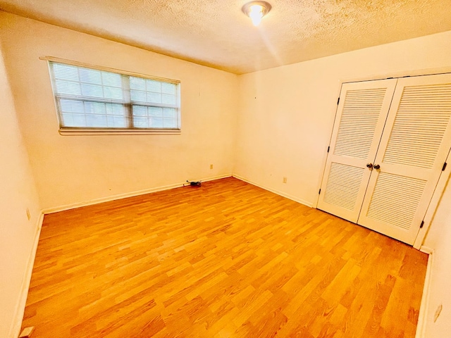 111 Van Deman Ct, Fitzgerald, GA 31750 - unfurnished bedroom featuring light wood-style flooring, a textured ceiling, a closet, and baseboards