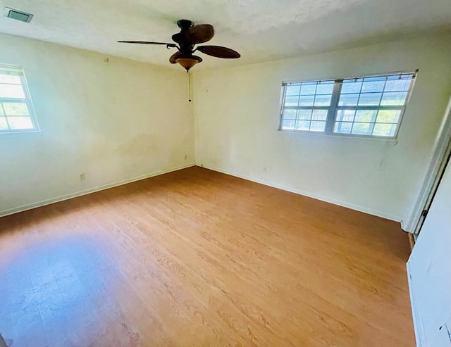 111 Van Deman Ct, Fitzgerald, GA 31750 - spare room featuring plenty of natural light, wood finished floors, a ceiling fan, and baseboards