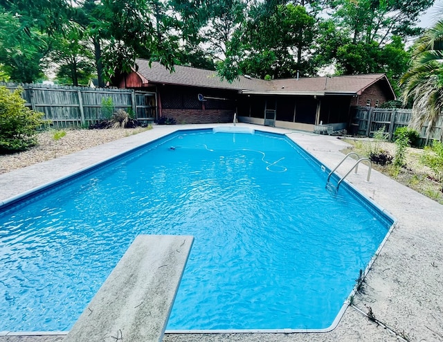 111 Van Deman Ct, Fitzgerald, GA 31750 - view of swimming pool featuring a sunroom, a diving board, and a fenced backyard