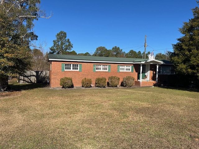 single story home featuring fence, a front lawn, and brick siding