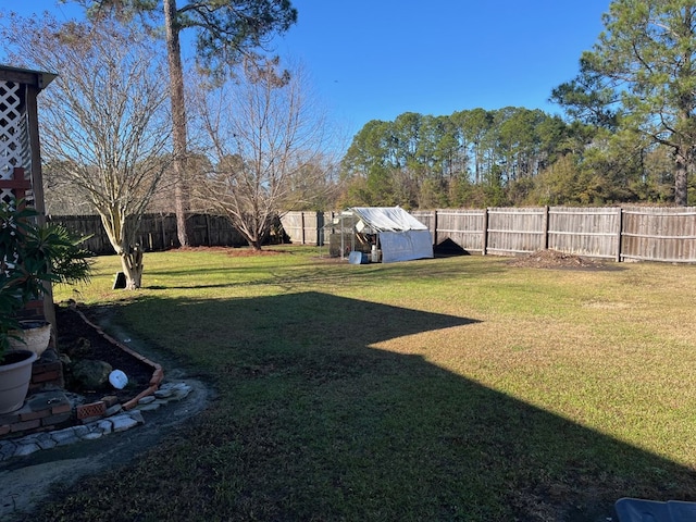 view of yard with a fenced backyard and an outdoor structure