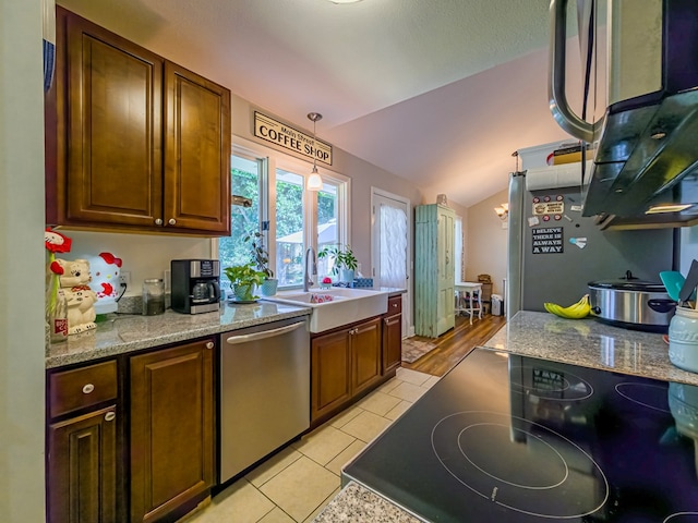 127 Carol Cir, Fitzgerald, GA 31750 - kitchen with stainless steel dishwasher, vaulted ceiling, black electric stovetop, light tile patterned floors, and decorative light fixtures