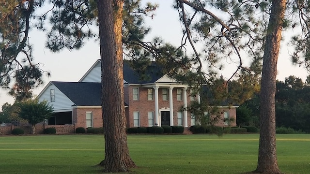 view of front of house with a front yard and brick siding