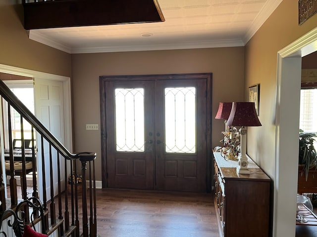 entrance foyer featuring crown molding, french doors, dark wood-style flooring, and a wealth of natural light