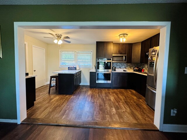 106 Pendley St, Sylvester, GA 31791 - kitchen with light countertops, appliances with stainless steel finishes, decorative backsplash, and dark wood finished floors