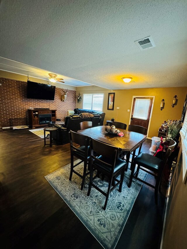 106 Pendley St, Sylvester, GA 31791 - dining room featuring a textured ceiling, a fireplace, dark wood finished floors, and visible vents