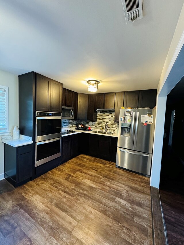 106 Pendley St, Sylvester, GA 31791 - kitchen with light countertops, backsplash, visible vents, dark wood finished floors, and appliances with stainless steel finishes