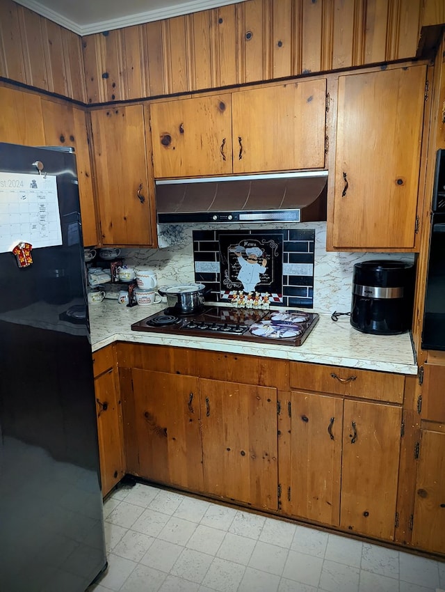 kitchen with brown cabinetry, under cabinet range hood, light countertops, and black appliances