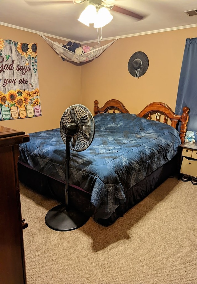 carpeted bedroom featuring a ceiling fan, ornamental molding, and visible vents