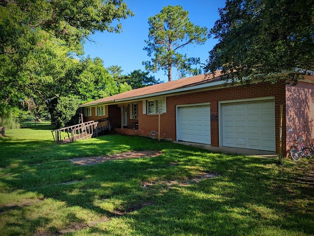back of property with brick siding, a garage, and a lawn