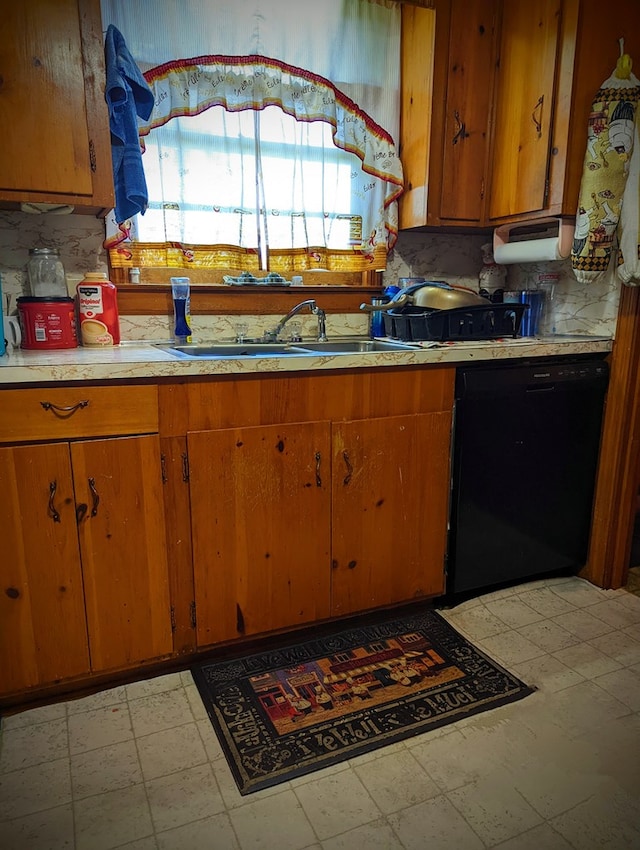 kitchen with brown cabinetry, dishwasher, a sink, and light floors
