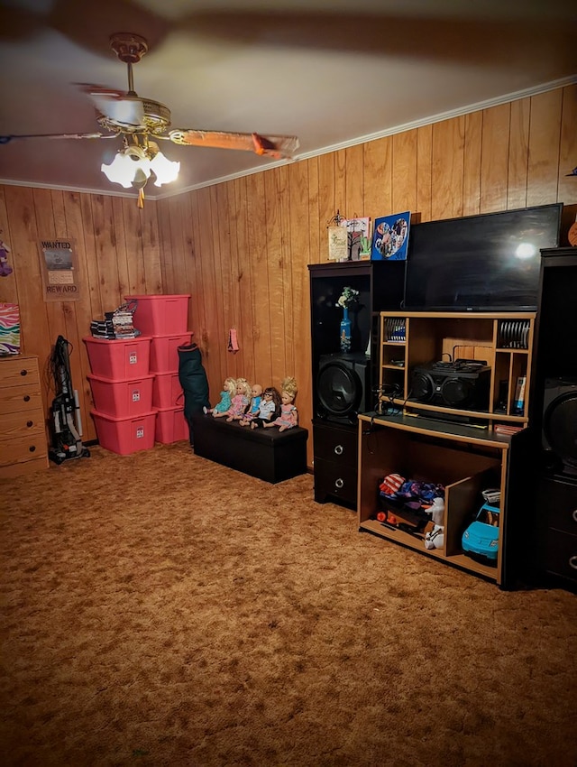 bedroom featuring crown molding, wood walls, a ceiling fan, and carpet flooring