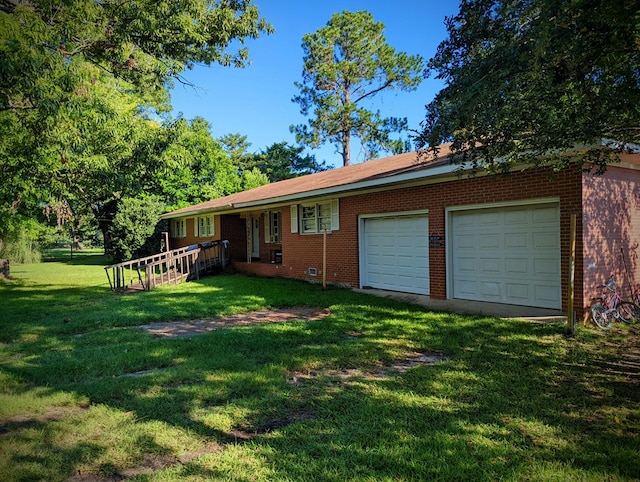rear view of house with brick siding, an attached garage, and a lawn