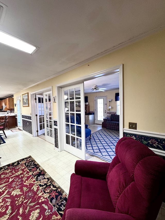 living area featuring crown molding, french doors, ceiling fan, and light tile patterned floors