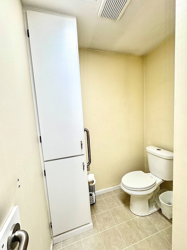 bathroom featuring toilet, tile patterned floors, baseboards, and visible vents