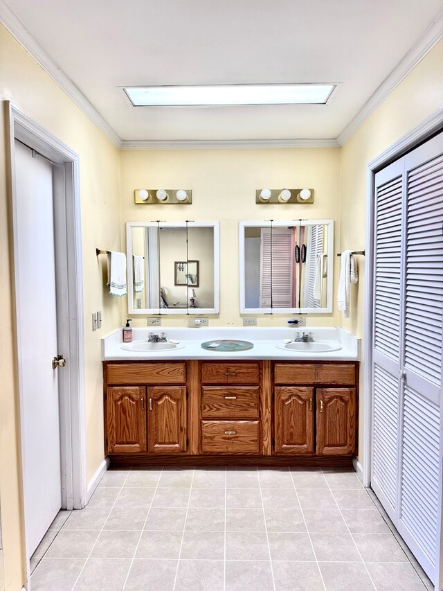 full bathroom with a sink, double vanity, tile patterned flooring, and crown molding