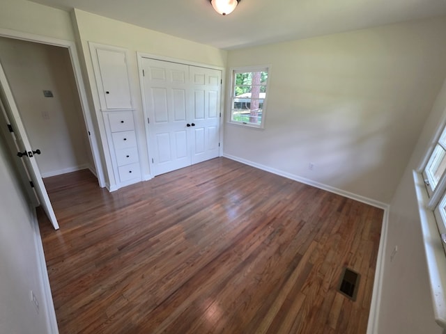 124 N Main St, Fitzgerald, GA 31750 - unfurnished bedroom with dark wood-type flooring and a closet
