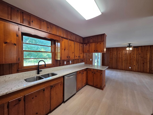 124 N Main St, Fitzgerald, GA 31750 - kitchen with stainless steel dishwasher, light wood-style flooring, brown cabinets, and wooden walls