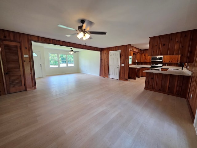 124 N Main St, Fitzgerald, GA 31750 - kitchen featuring open floor plan, stainless steel appliances, a ceiling fan, a peninsula, and light countertops