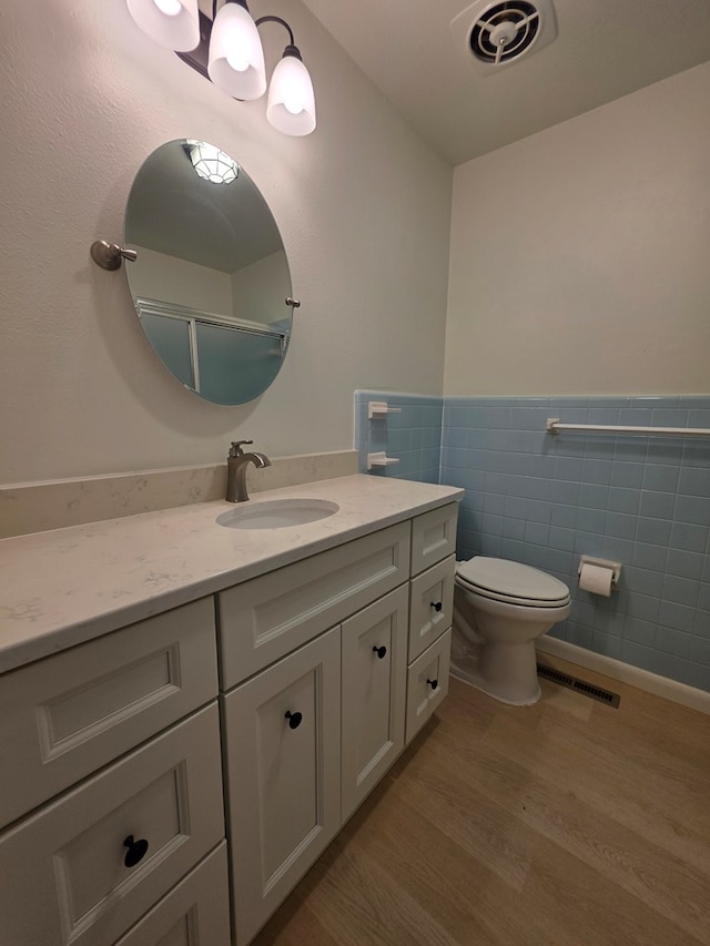 124 N Main St, Fitzgerald, GA 31750 - full bath with tile walls, wood finished floors, vanity, a wainscoted wall, and a shower