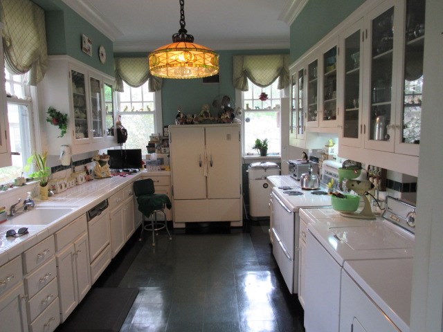 kitchen with crown molding, white cabinetry, tile countertops, and separate washer and dryer