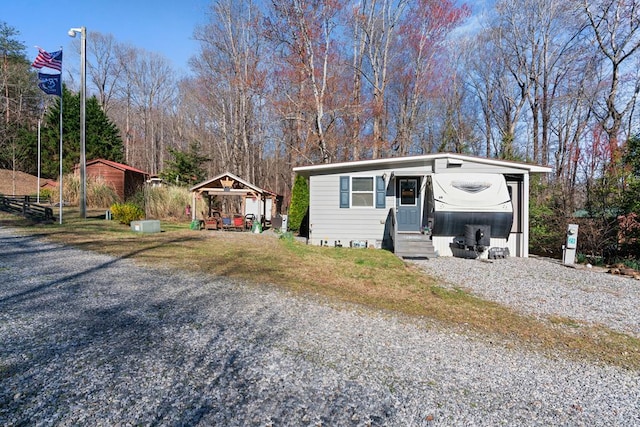 28 Bear Lovers Ct, Cleveland, GA 30528 - view of front of house with a carport, entry steps, an outbuilding, and a front lawn