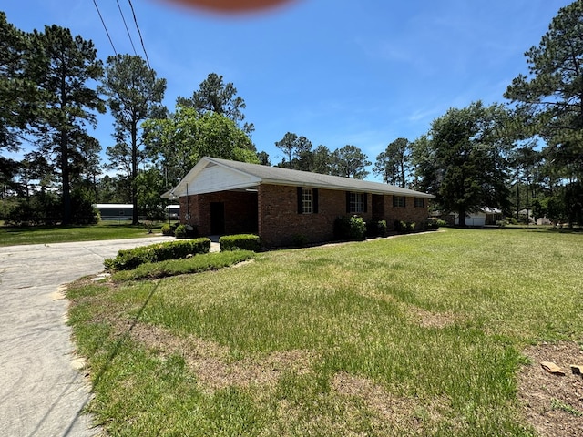 142 Elva Cir, Enigma, GA 31749 - view of front of property with concrete driveway, brick siding, a front lawn, and an attached carport