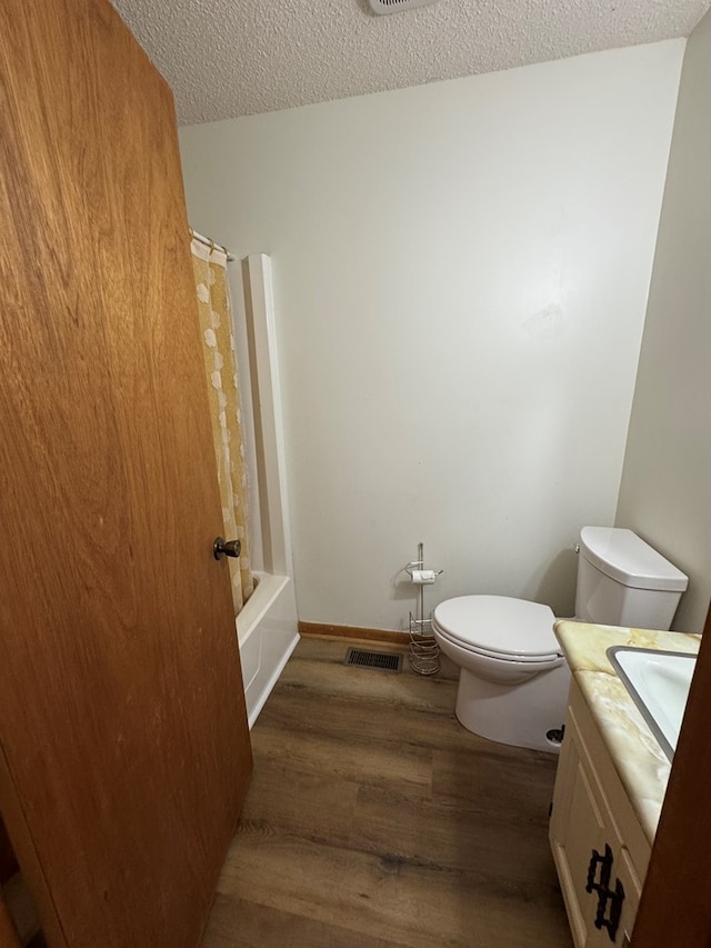 142 Elva Cir, Enigma, GA 31749 - full bath featuring vanity, wood finished floors, toilet, a textured ceiling, and shower / bath combination with curtain