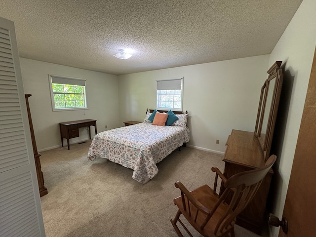 142 Elva Cir, Enigma, GA 31749 - bedroom with a textured ceiling, multiple windows, light colored carpet, and baseboards