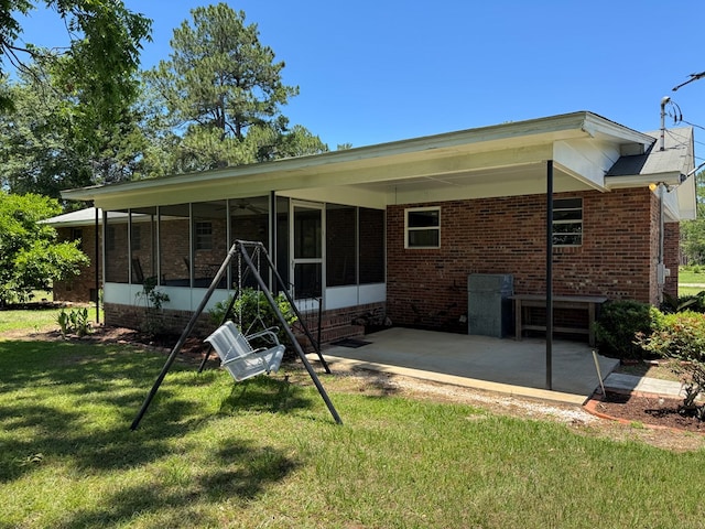 142 Elva Cir, Enigma, GA 31749 - rear view of property featuring a sunroom, a lawn, and brick siding