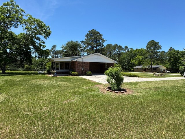 142 Elva Cir, Enigma, GA 31749 - view of front of property with driveway, an attached carport, and a front yard