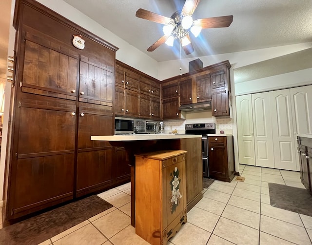 109 Preston Dr, Fitzgerald, GA 31750 - kitchen with under cabinet range hood, light tile patterned floors, stainless steel microwave, light countertops, and ceiling fan