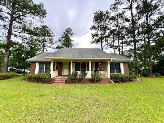 109 Preston Dr, Fitzgerald, GA 31750 - view of front of house featuring covered porch, brick siding, a front yard, and a shingled roof