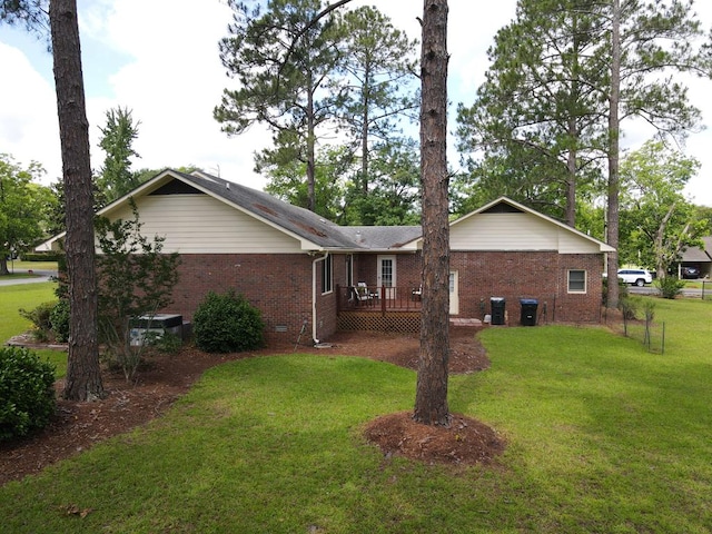 109 Preston Dr, Fitzgerald, GA 31750 - back of house featuring brick siding, a lawn, and a wooden deck