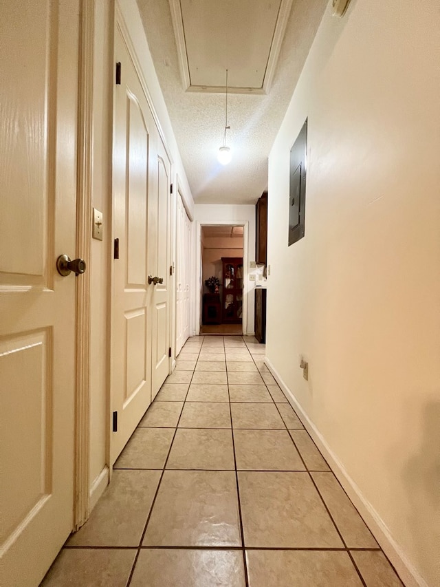 109 Preston Dr, Fitzgerald, GA 31750 - corridor featuring attic access, light tile patterned flooring, electric panel, and a textured ceiling