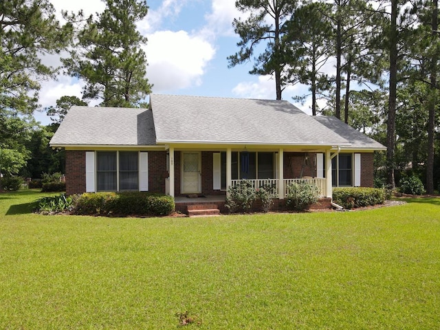 109 Preston Dr, Fitzgerald, GA 31750 - view of front facade featuring covered porch, brick siding, a front lawn, and a shingled roof