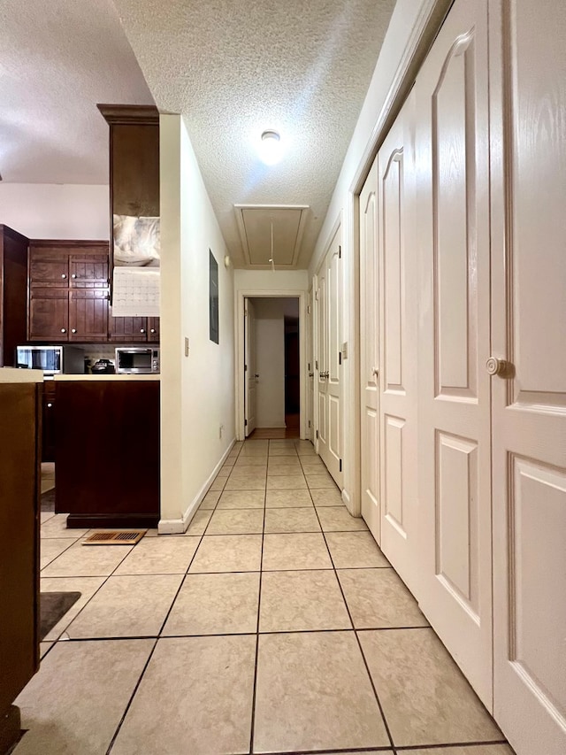109 Preston Dr, Fitzgerald, GA 31750 - corridor featuring attic access, a textured ceiling, and light tile patterned flooring