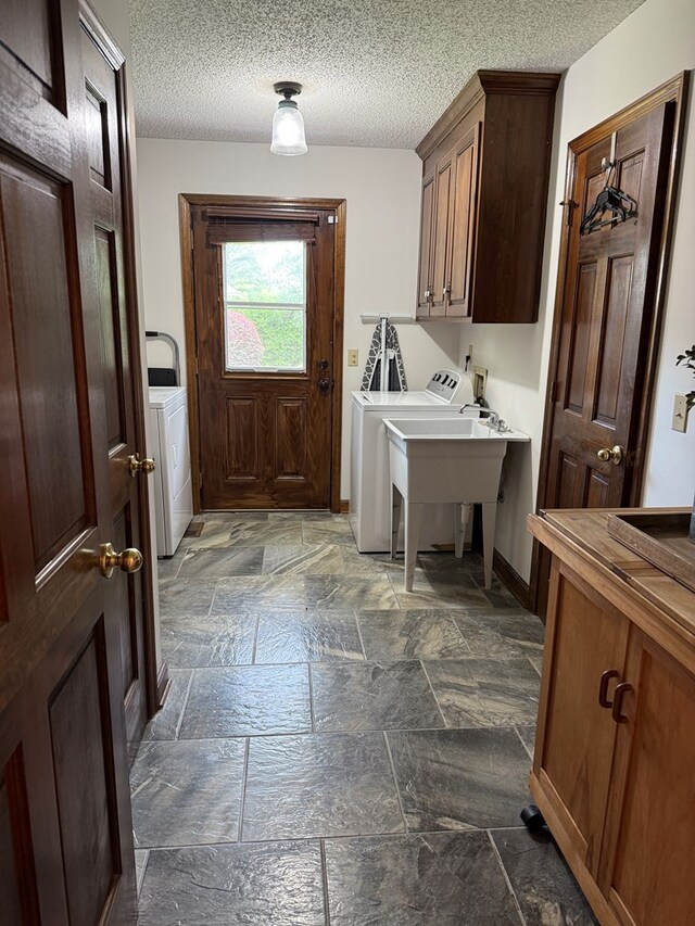 7222 E Northgate Dr, Tifton, GA 31794 - laundry area featuring cabinet space, stone tile flooring, washing machine and clothes dryer, baseboards, and a textured ceiling