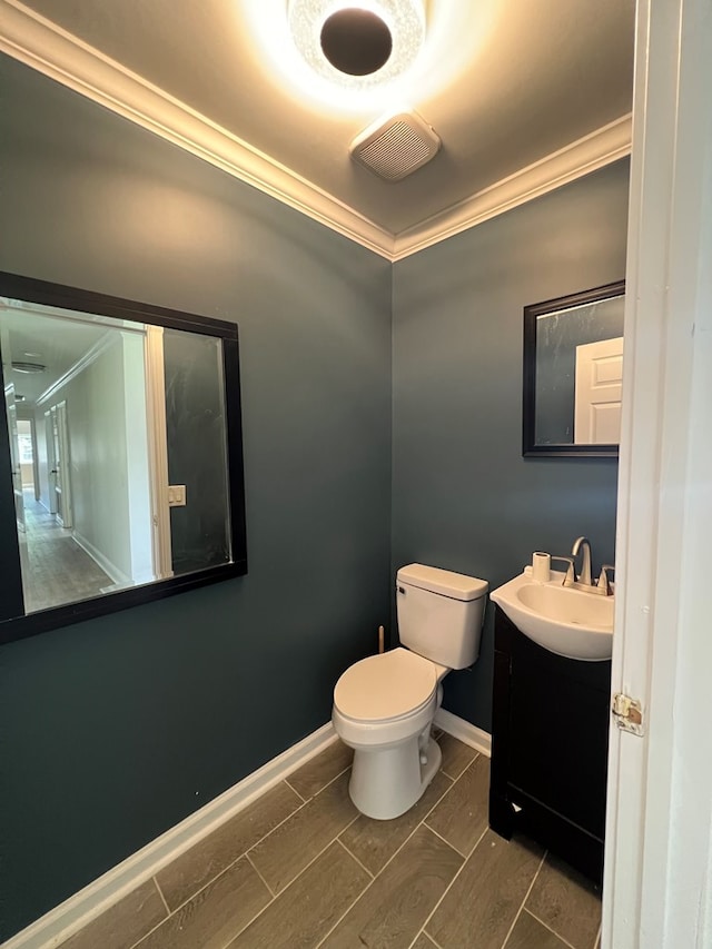 315 Newton Dr, Adel, GA 31620 - half bathroom with ornamental molding, toilet, vanity, and baseboards