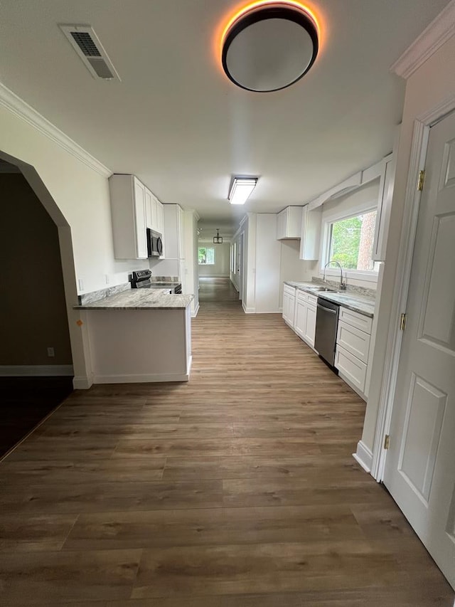 315 Newton Dr, Adel, GA 31620 - kitchen with appliances with stainless steel finishes, ornamental molding, a sink, white cabinets, and dark wood-type flooring