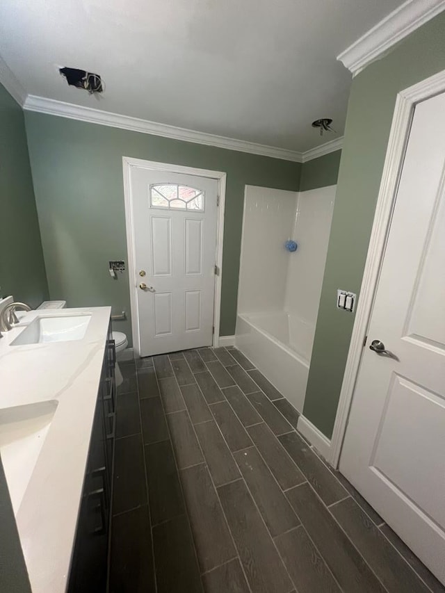 315 Newton Dr, Adel, GA 31620 - bathroom featuring ornamental molding, wood finish floors, washtub / shower combination, toilet, and double vanity