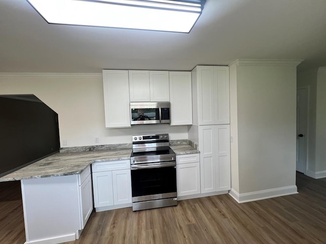 315 Newton Dr, Adel, GA 31620 - kitchen featuring appliances with stainless steel finishes, a peninsula, light wood-type flooring, white cabinets, and ornamental molding