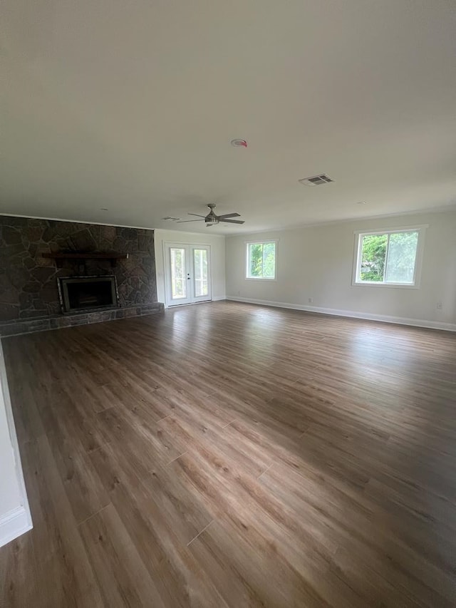 315 Newton Dr, Adel, GA 31620 - unfurnished living room with wood finished floors, a stone fireplace, baseboards, and a ceiling fan