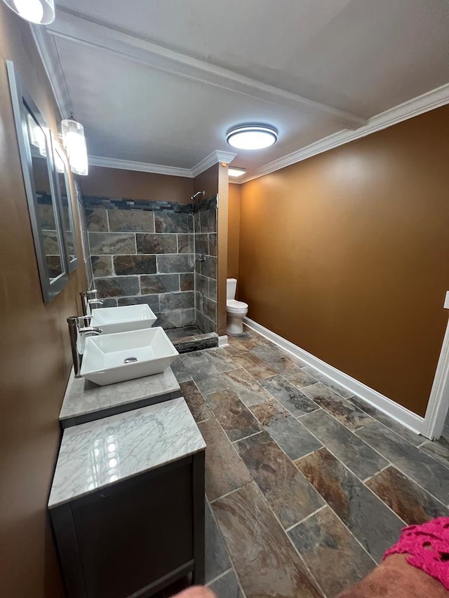 315 Newton Dr, Adel, GA 31620 - bathroom featuring baseboards, stone tile flooring, a tile shower, toilet, and double vanity