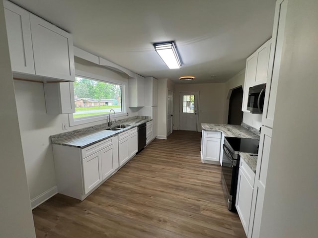 315 Newton Dr, Adel, GA 31620 - kitchen featuring black appliances, baseboards, a sink, wood finished floors, and white cabinets