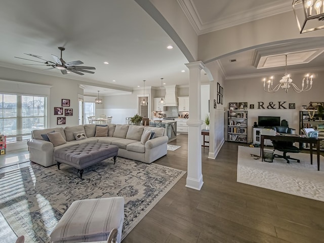 living room with dark wood finished floors, recessed lighting, arched walkways, ornamental molding, and ceiling fan with notable chandelier